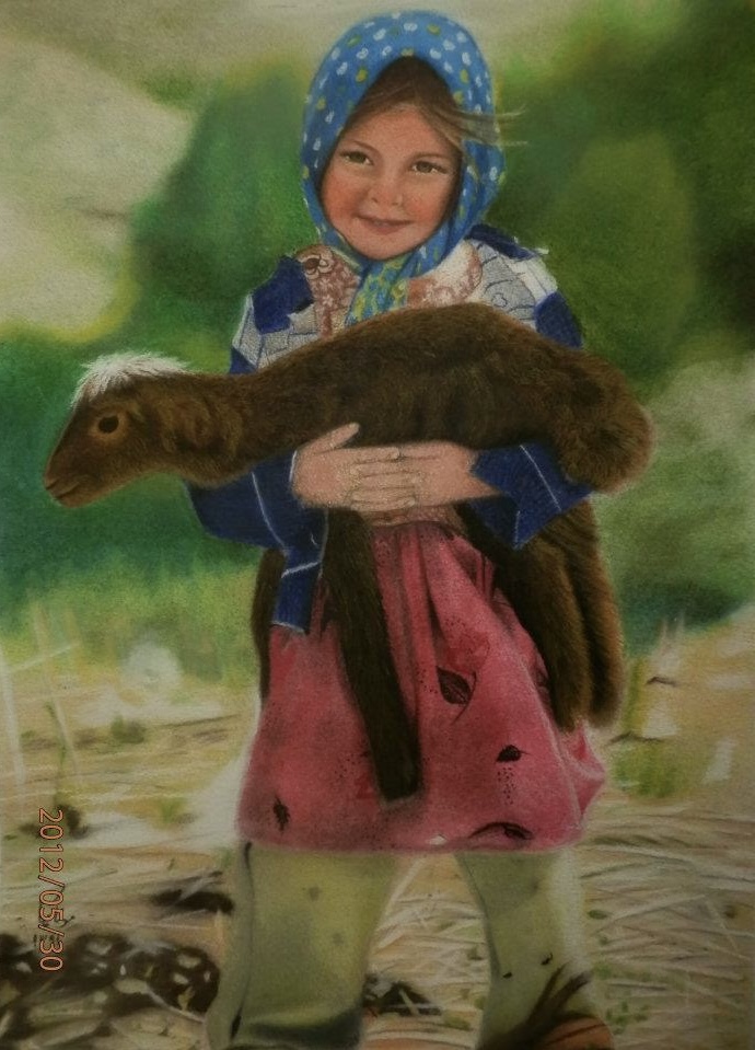 A smiling child wearing a blue headscarf and colourful dress holds a small animal in her arms while standing outdoors in a soft, green landscape.