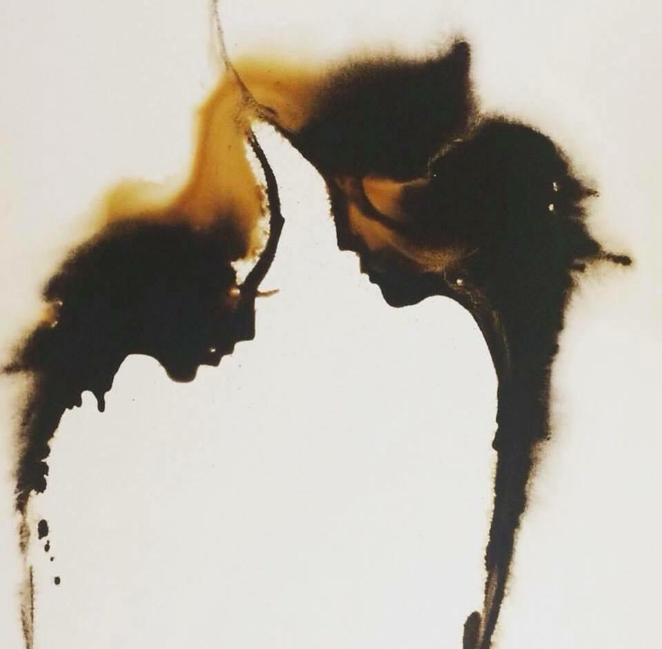 Abstract ink painting forming two human profiles facing each other, created with dark flowing shapes on a light background.